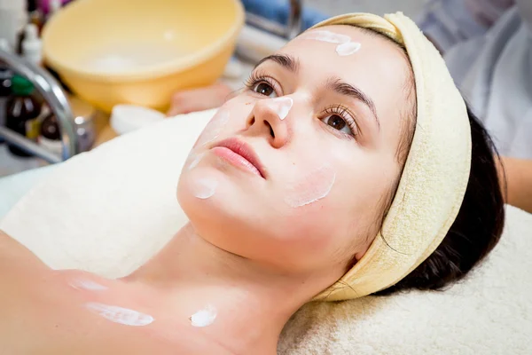 Cosmetólogo aplican la crema a la persona de la mujer — Foto de Stock