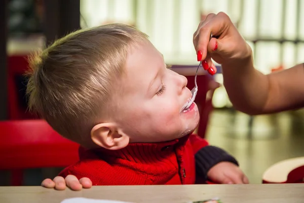 男の子はスプーンから食べる — ストック写真