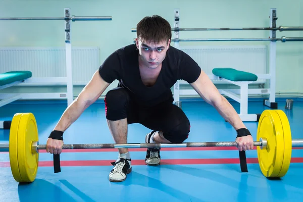 Sportsman pushing barbell — Stock Photo, Image