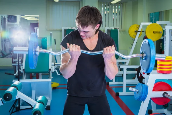 Sportsman pushing barbell — Stock Photo, Image