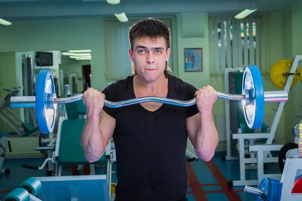 Sportsman pushing barbell — Stock Photo, Image