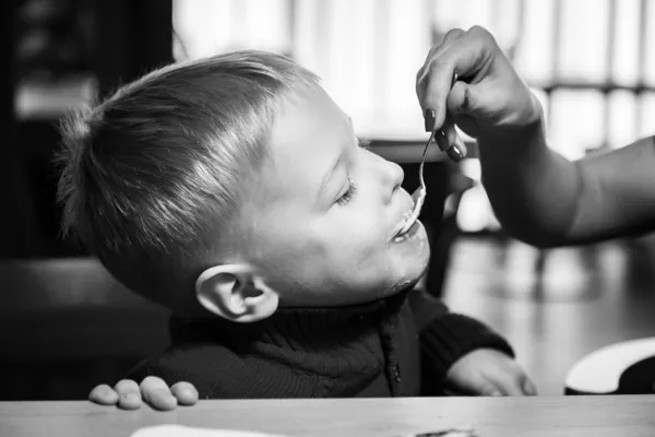 小さな男の子はスプーンから食べる — ストック写真