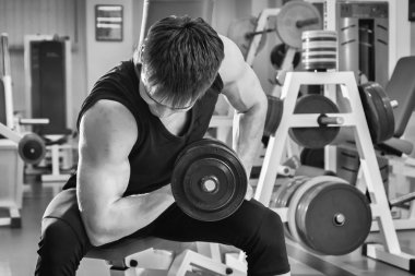 Dambıllarla egzersiz yapan adam.