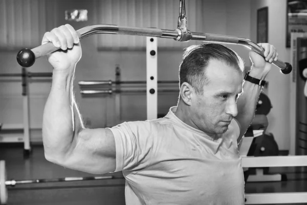 Man shakes his back on the simulator — Stock Photo, Image