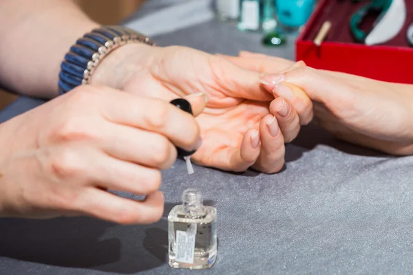 Esteticista aplicando barniz de uñas a las uñas de un cliente —  Fotos de Stock