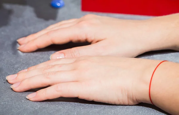 Belas mãos femininas com verniz incolor nas unhas — Fotografia de Stock