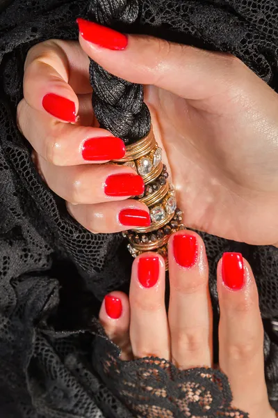 Manos femeninas con manicura roja sobre un encaje negro —  Fotos de Stock