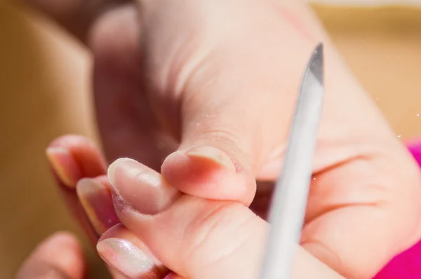 Nail beautician polishing nails — Stock Photo, Image
