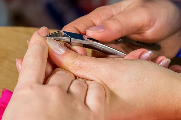 Beautician trimming cuticles of female client — Stock Photo, Image