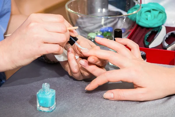 Kosmetyczka stosowania paznokci niebieski lakier do paznokci klienta — Zdjęcie stockowe