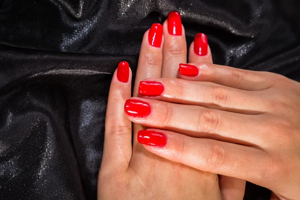 Beautiful female hands with red nail polish on the nails — Stock Photo, Image