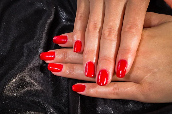 Beautiful female hands with red nail polish on the nails — Stock Photo, Image