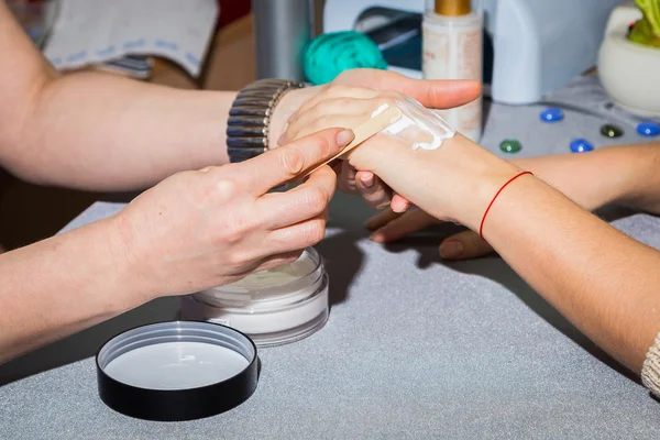 Nail salone manicure donna applicando crema per le mani — Foto Stock