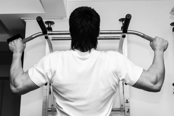 Man hanging from a pull up bar