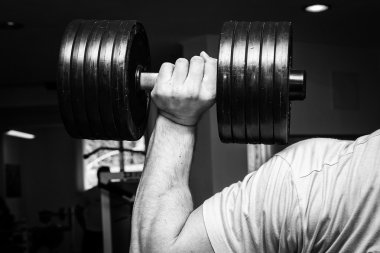 spor salonunda halter alıştırmalar yapan erkek