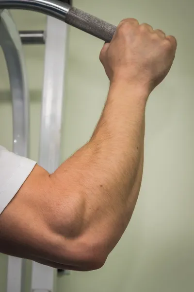 Man hanging from a pull up bar. — Stock Photo, Image