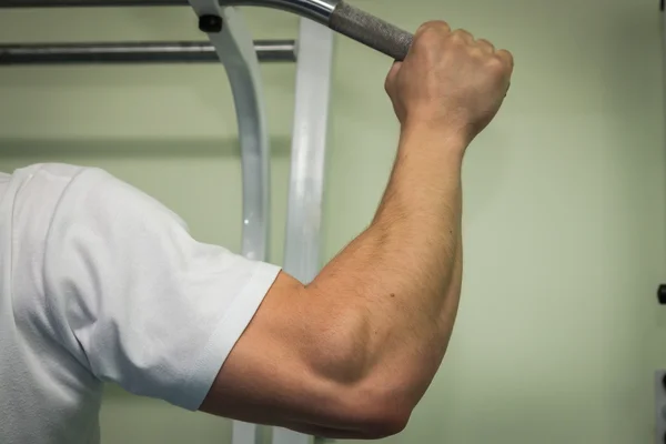 Man hanging from a pull up bar. — Stock Photo, Image