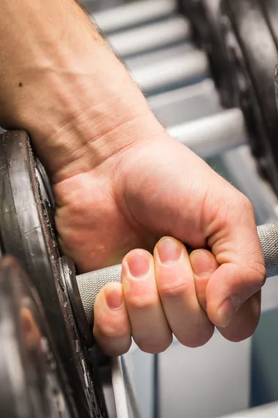 Hombre haciendo ejercicios con mancuerna en el gimnasio . — Foto de Stock