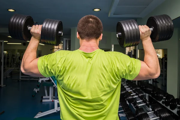 Homem fazendo exercícios com halteres — Fotografia de Stock