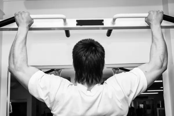 Man opknoping van een pull up bar. — Stockfoto