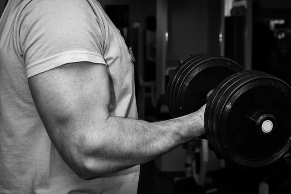 Hombre haciendo ejercicios con mancuerna en el gimnasio — Foto de Stock