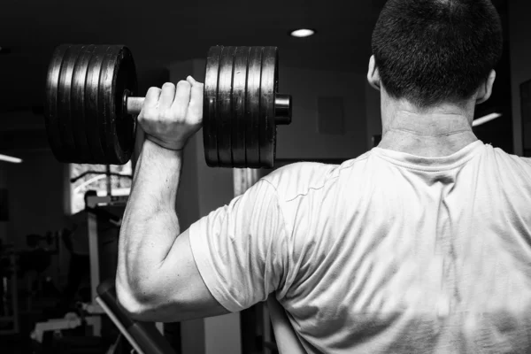 Uomo che fa esercizi con manubri in palestra — Foto Stock