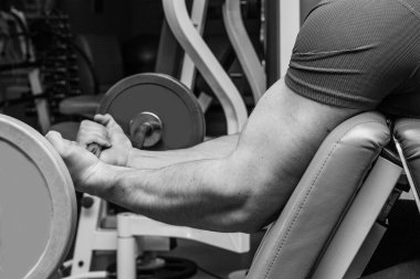 Dambıllarla egzersiz yapan adam.