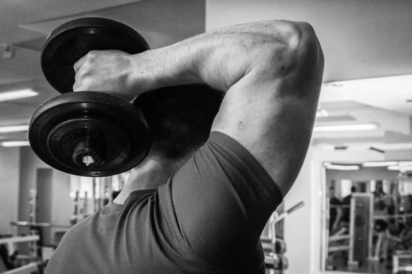 Homem treinando com halteres — Fotografia de Stock