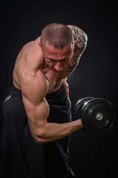 Muscle man in tattoos with dumbbells — Stock Photo, Image