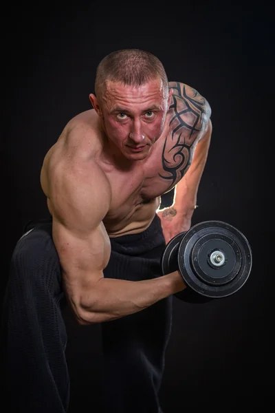 Muscle man in tatoeages met halters — Stockfoto