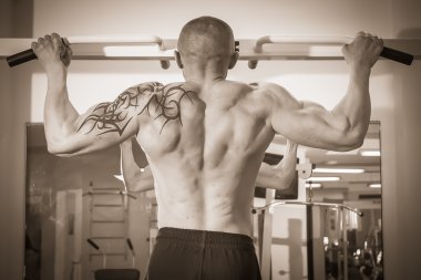 spor salonunda egzersiz dövmesi olan adam