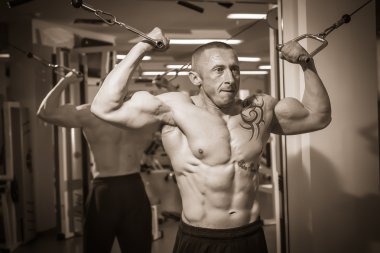 spor salonunda egzersiz dövmesi olan adam