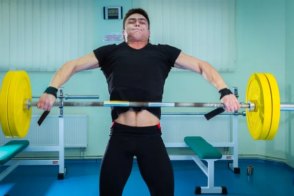 Sportsman pushing barbell — Stock Photo, Image