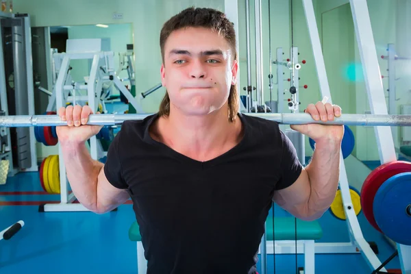 Sportsman pushing barbell — Stock Photo, Image