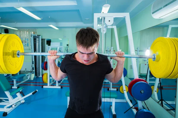 Sportsman pushing barbell — Stock Photo, Image