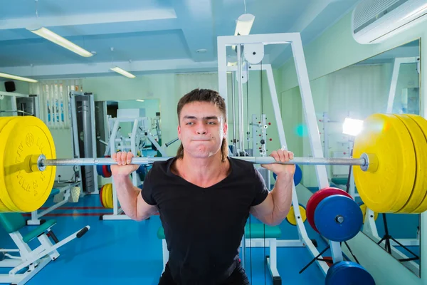 Sportsman pushing barbell — Stock Photo, Image