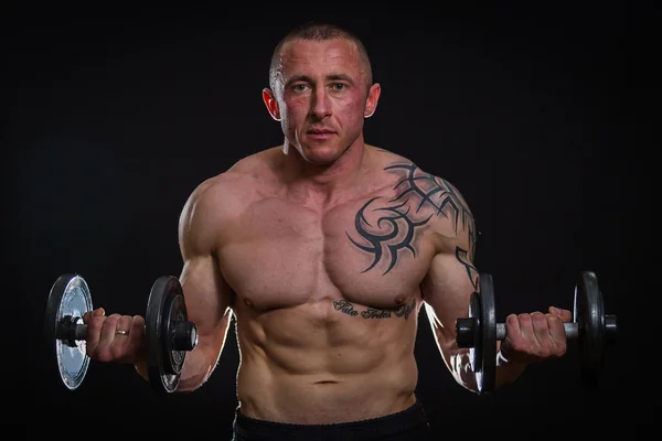 Muscle man with dumbbells — Stock Photo, Image