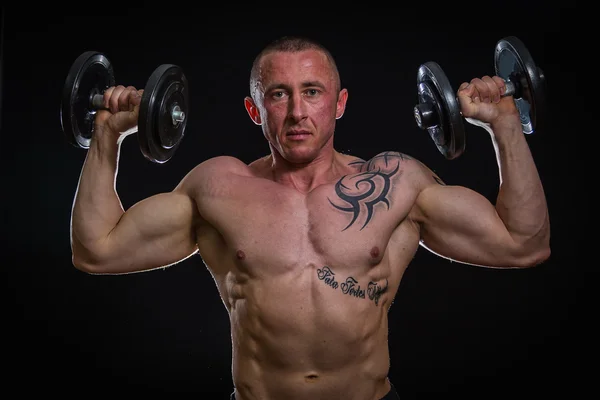 Muscle man with dumbbells — Stock Photo, Image