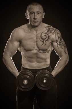 vücut geliştirmeci dumbbells ile