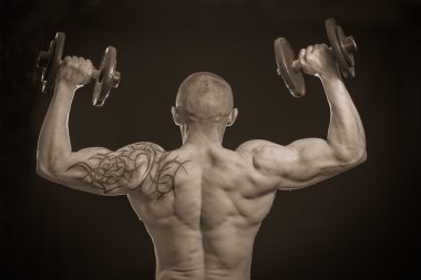 vücut geliştirmeci dumbbells ile
