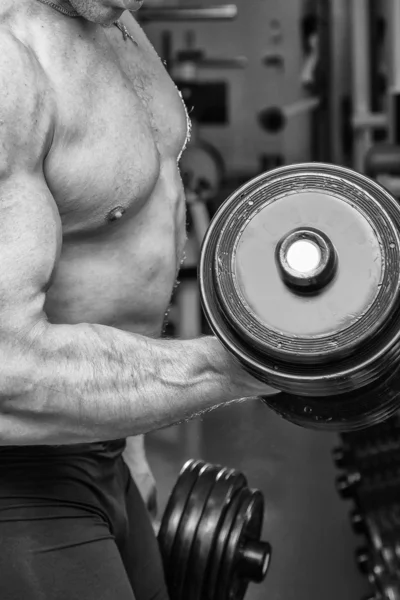 Uomo che lavora con i manubri in palestra — Foto Stock