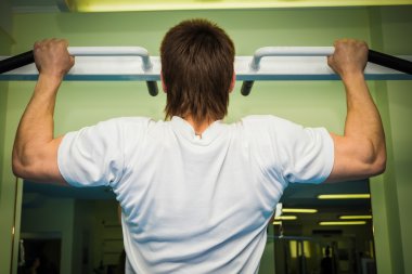 erkek spor egzersizleri yatay çubuk üzerinde gerçekleştirir.