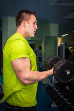 Dambıllarla egzersiz yapan adam.