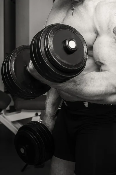 Hombre haciendo ejercicio con pesadas mancuernas — Foto de Stock