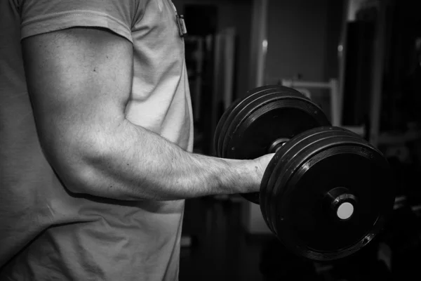 Hombre haciendo ejercicio con pesadas mancuernas — Foto de Stock