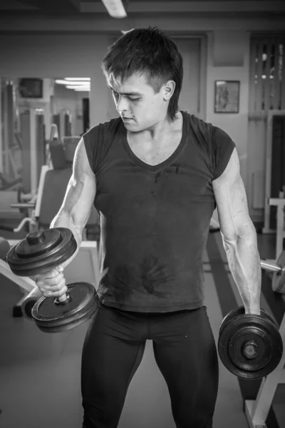 Uomo che lavora con i manubri in palestra — Foto Stock