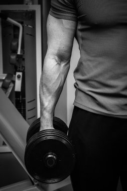 Dambıllarla egzersiz yapan adam.