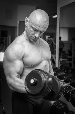 Dambıllarla egzersiz yapan adam.