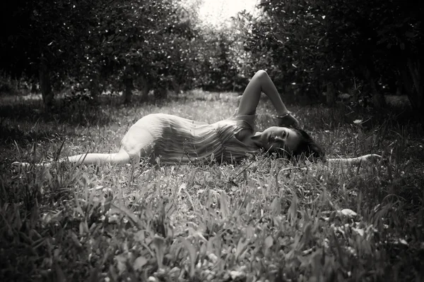 ブルネットの草で横になっています。 — ストック写真