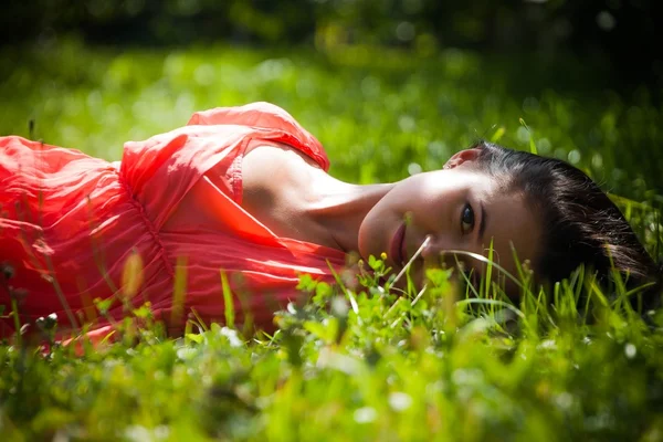 Brunette liggen in het gras — Stockfoto